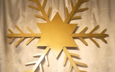 Gold star/snowflake against white background