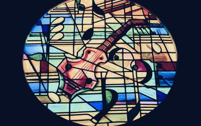 Stained glass window with stringed instrument and music symbols