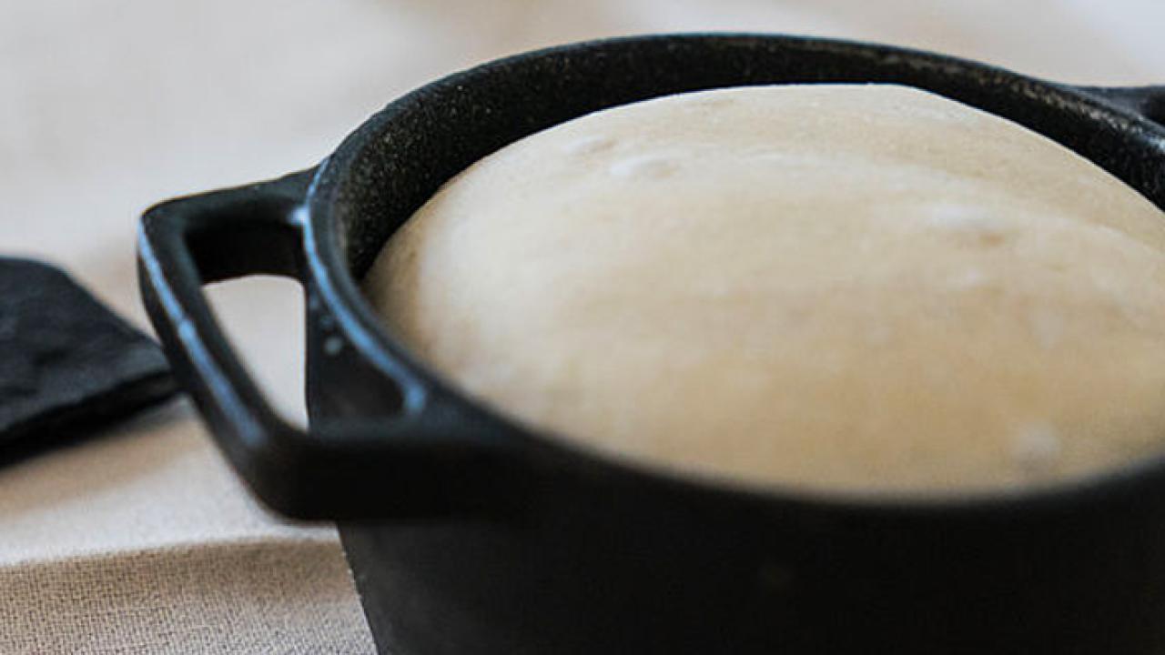 Bread being baked in a cast iron pot.