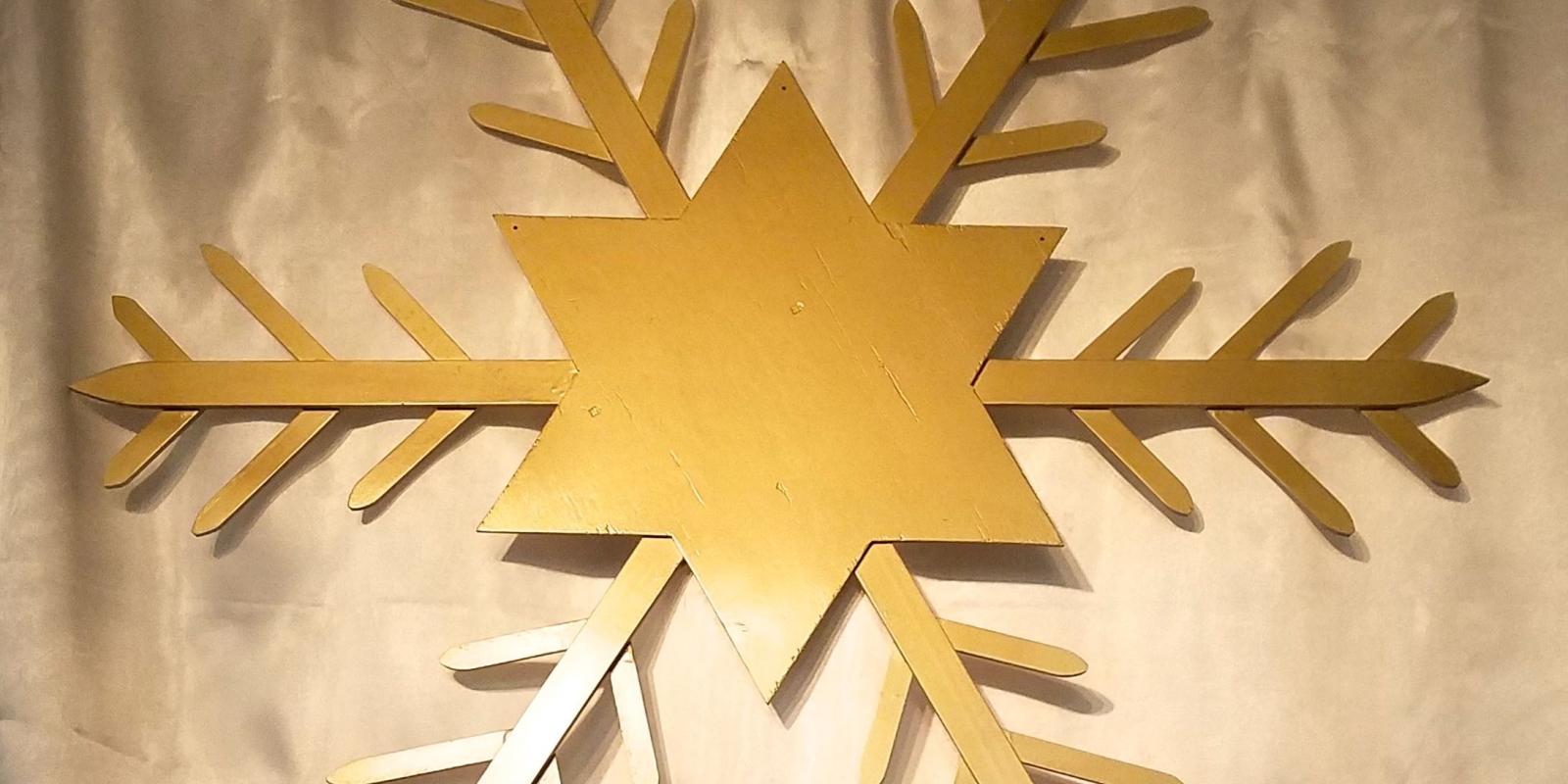 Gold star/snowflake against white background